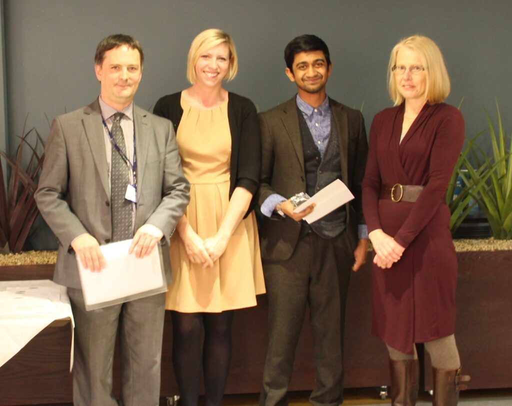 two men and two women smiling and holding awards