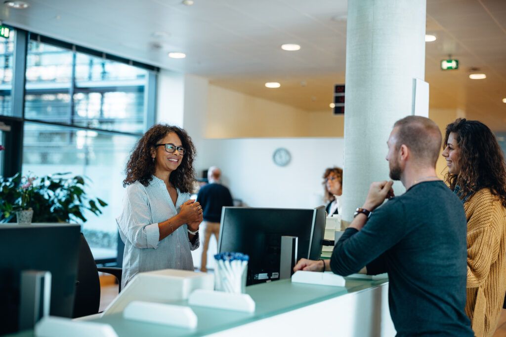 Receptionist greeting client to office