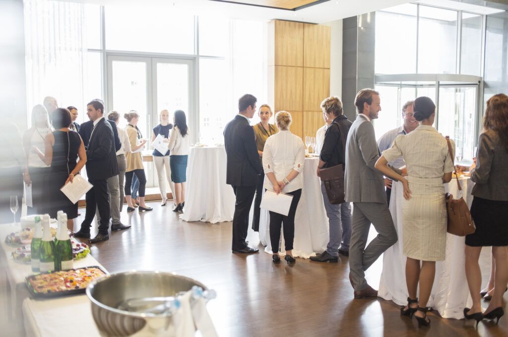 Crowd of people stood around tables at a conference centre