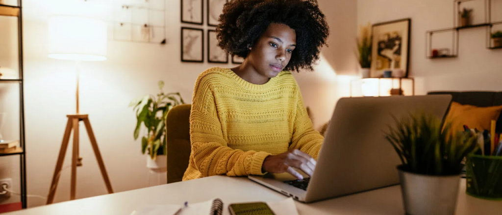 Lady working at laptop writing from a cover letter template