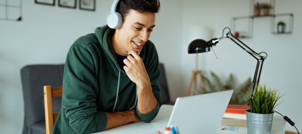 Man wearing headphones working on laptop