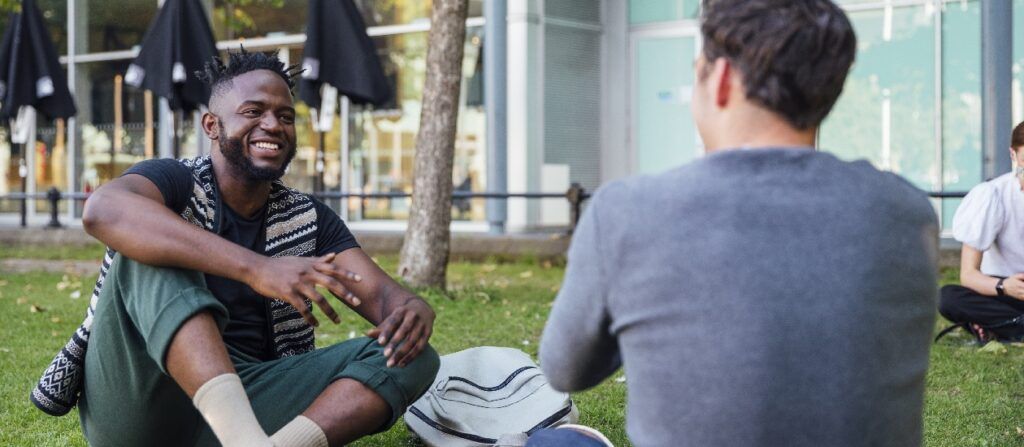 Two male students outside on campus talking