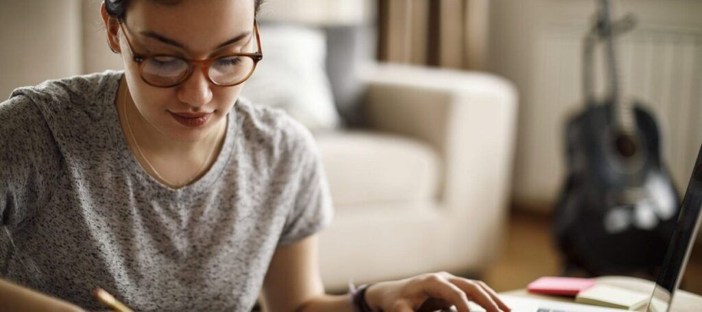 Woman at desk checking things off list