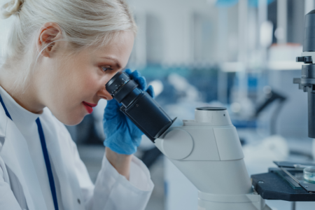 Woman looking through microscope in lab 1