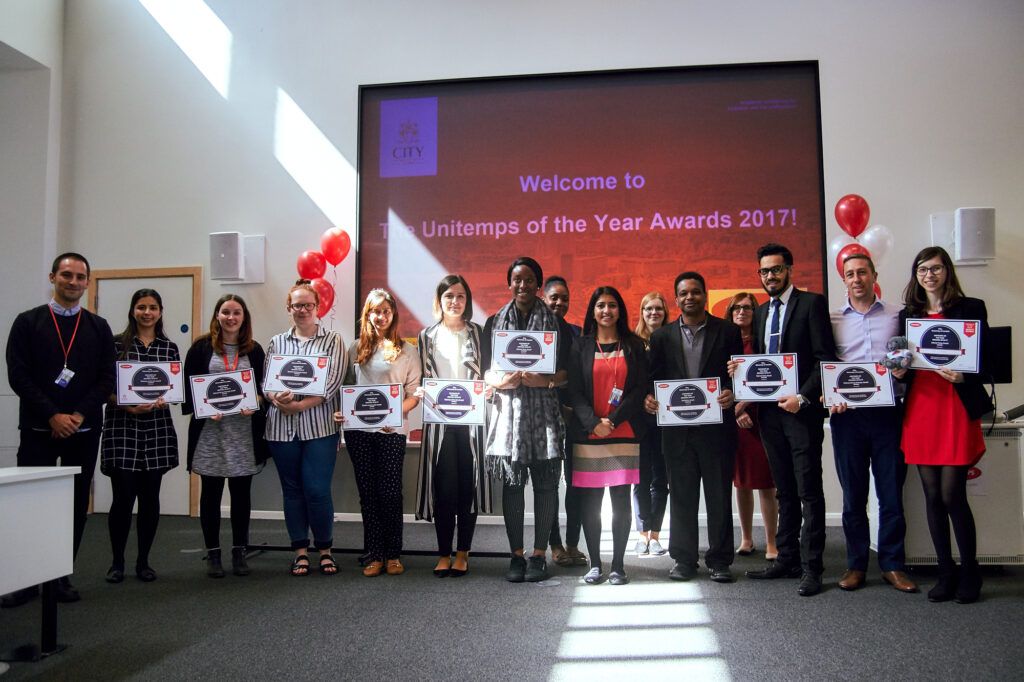 mixed group of people standing holding awards and certificates at conference