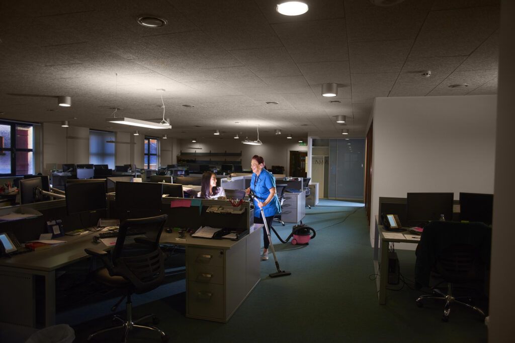 lady hoovering a dark empty office