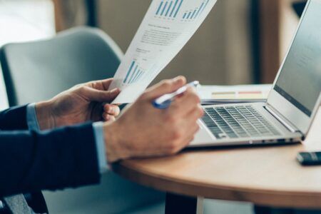 man at desk with laptop and documents