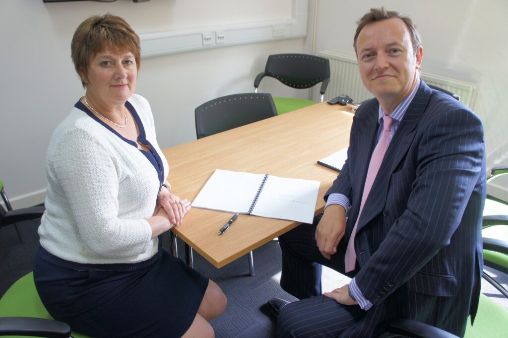 unitemps director and female colleague sitting at desk smiling