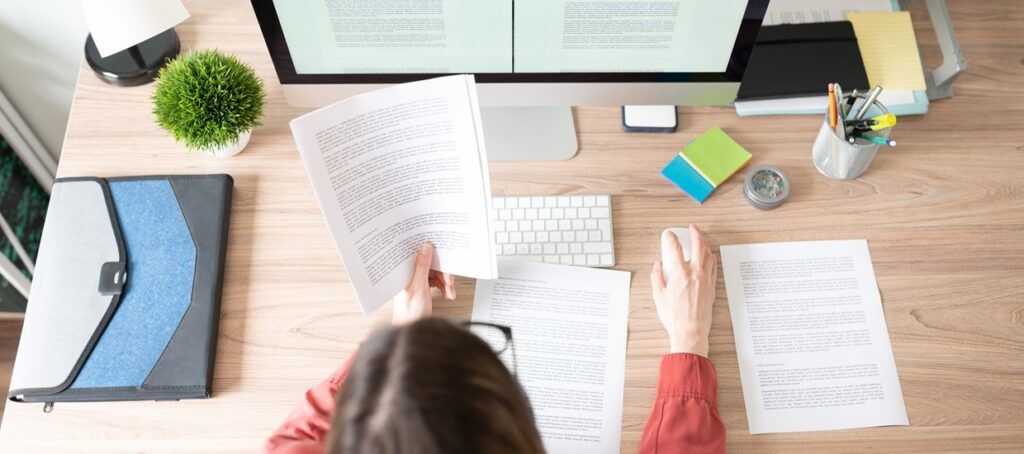 woman at desk going through paperwork